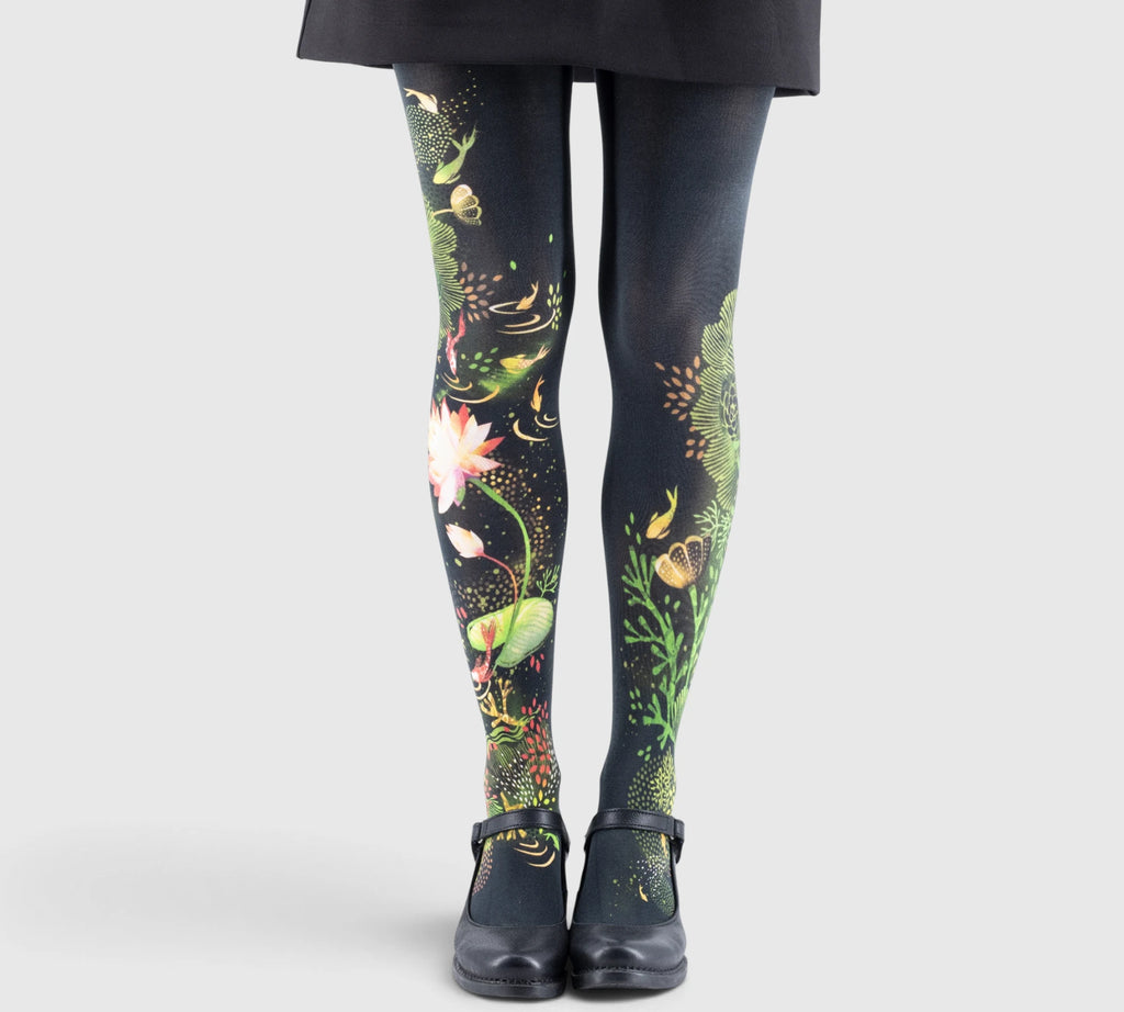 Jambes d'une enfant portant des collants imprimés floraux et herbes aquatiques, chaussures noires à bride.