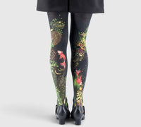 Jambes féminines portant des collants imprimés plage marine et poissons; vue arrière, pieds en escarpins noirs.