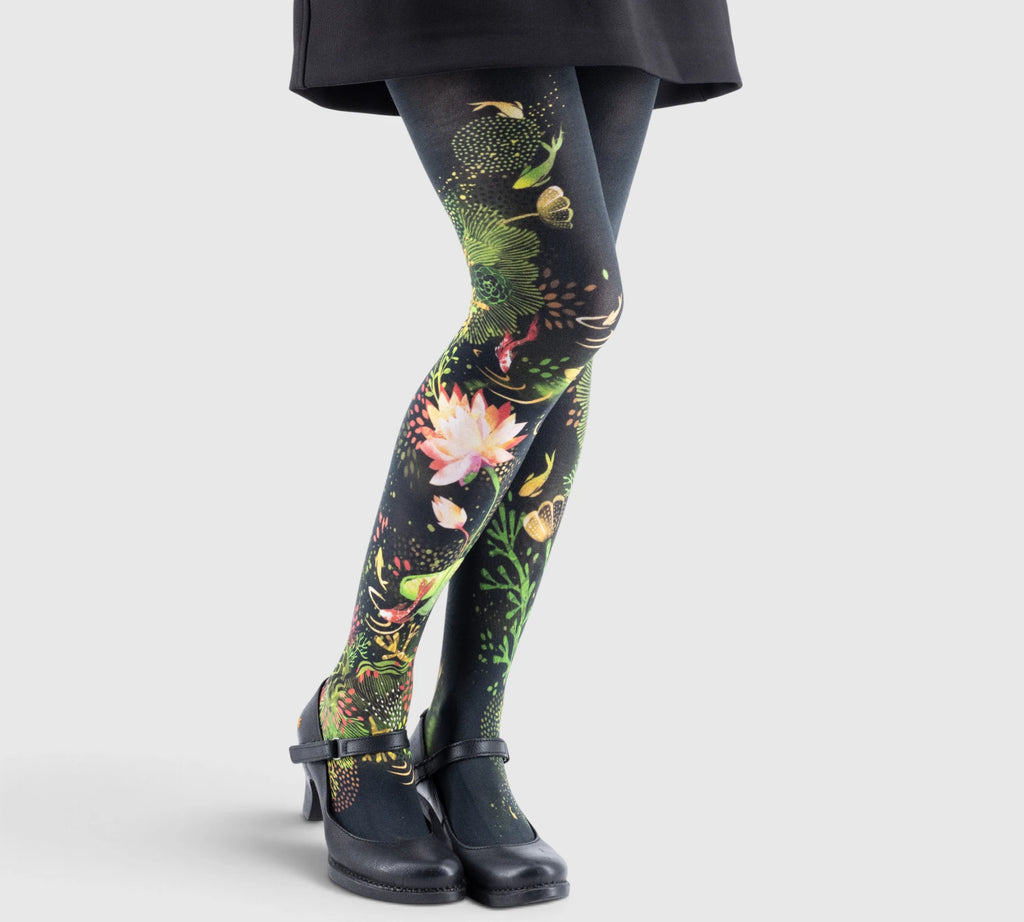 Leggings imprimés floraux volumineux sur fond noir, associées à des chaussures noires à petits talons et brides.